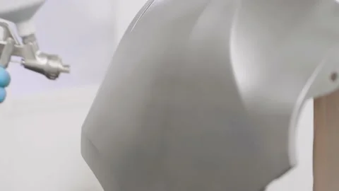 Auto painter spraying silver paint on the rear bumper of the car in special Stock Footage 146178539