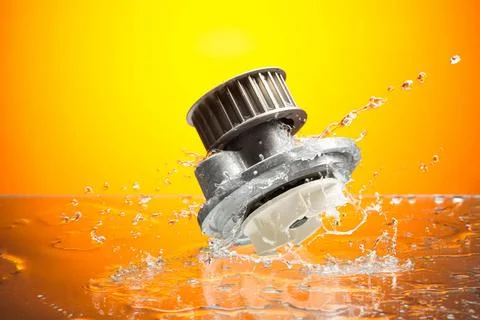 Auto parts, engine cooling pump in water splash on orange background Auto ... Foto stock