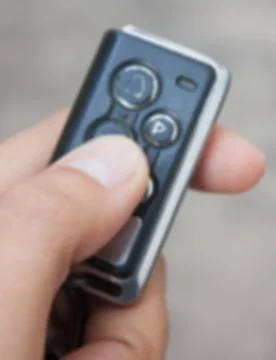 Auto remote key pressed by the finger  blur background. Stock Photos