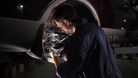 Auto repair service worker checking running gear Stock Footage 123507487