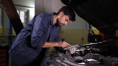 Auto repair specialist using tablet pc during work Video stock 123505939