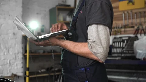 Auto repairman diagnoses a car using a computer. car workshop. close-up Stock Footage 204082746