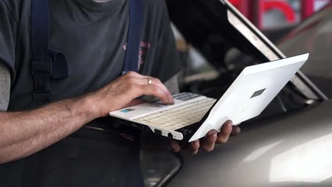 Auto repairman diagnoses a car using a computer. car workshop. close-up Видео 207787270