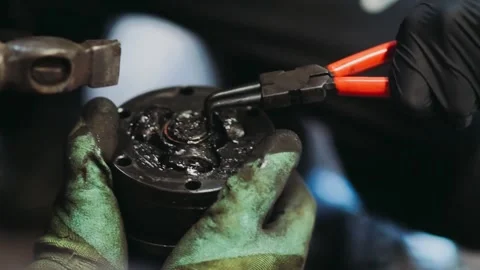 Auto repairman remove the CV joint retaining ring with clamps. Stock Footage 139167515