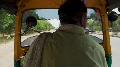 Auto rickshaw driver on sunny road seen from inside tuk tuk Stock Footage 333380496