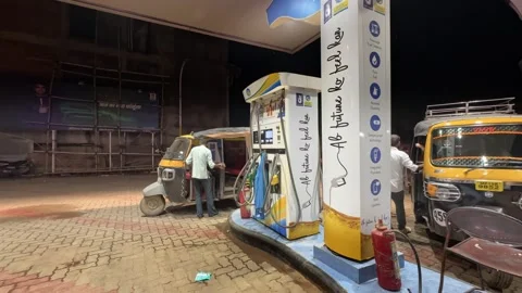 Auto rickshaw queuing up at the petrol pump station at night Stock Footage 295649096