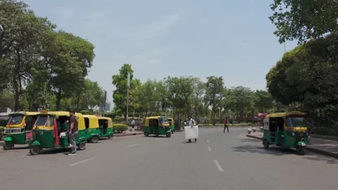 Auto rickshaws parked on a wide empty road near Connaught Place Stock Footage 316836854