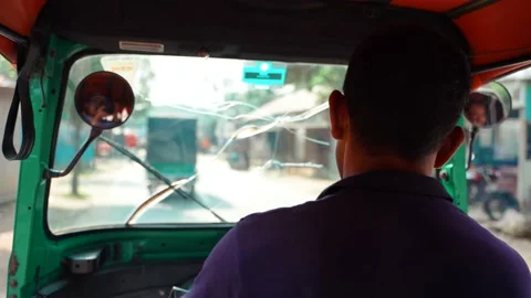 An auto rikshaw driver driving his vehicle in the road Stock Footage 164512428
