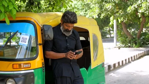 An auto rikshaw driver having a phone call while standing out of the vehicle ... Stock Footage 260802604