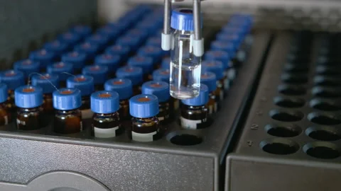 Auto sampler takes a vial and injects a sample into high performance liquid Stock Footage 140921620