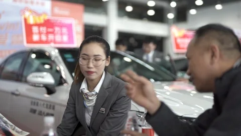 At auto shows, customers ask for information and sales consultants answer. Stock Footage 125373215