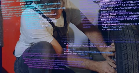 Auto tech crouching in garage hands securing wheel as purple or blue code Stock Footage 329946413