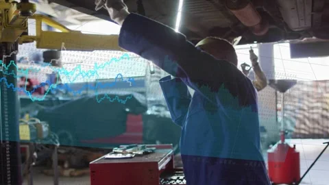 Auto tech fixing under vehicle after lift up, line-graphs sweeping across garage Stock Footage 333105647