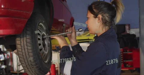 Auto tech placing socket on lug turning wrench loosening nuts for repair text Stock Footage 330191250