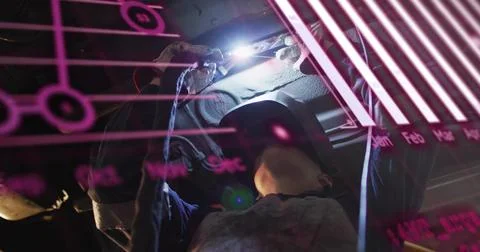 Auto tech shining LED light under raised vehicle, inspecting parts causing Stock Photos