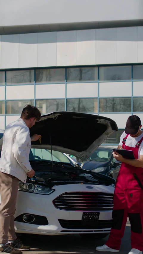 Auto technician consulting with customer about car maintenance, inspecting Stock Footage 318346276
