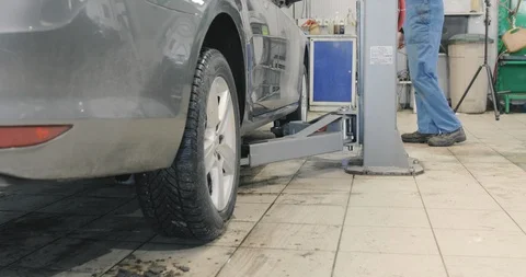 Auto Technician Is Raising A Car, Using Electric Hydraulic Hoist Video stock 125012700