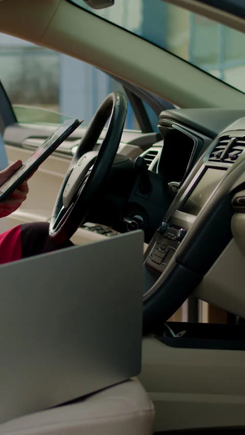 Auto technician in red overalls diagnosing car air conditioning system with Stock Footage 320959203