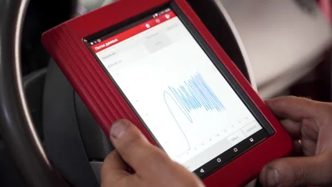 Auto technician uses OBD2 scanner and tablet to check vehicle engine codes Stock Footage 270227345