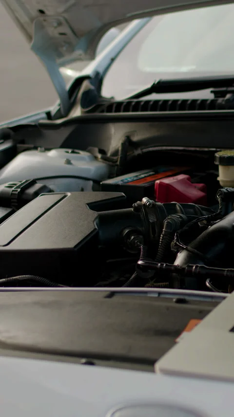 Auto technician using laptop for diagnostics on car air conditioning system Stock Footage 318346304