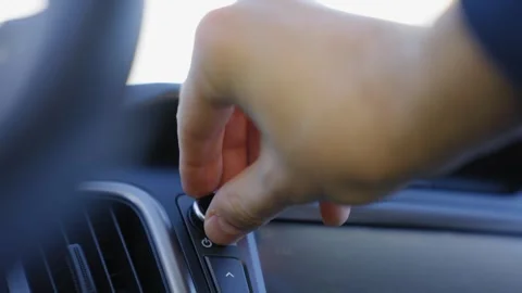 Auto technology concept.close-up of hands turning volume button of car radio Stock Footage 268173419