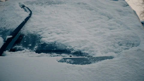 Auto wipers clears snow from car window. Closeup Stock Footage 102928545