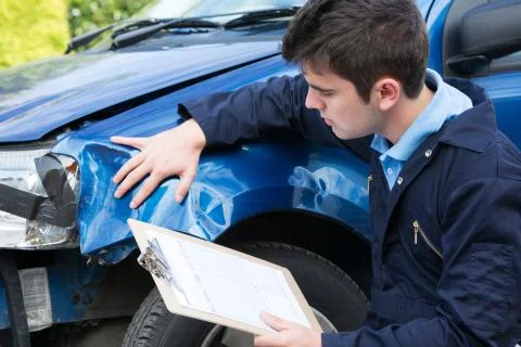 Auto Workshop Mechanic Inspecting Damage To Car And Filling In Repair Estimat Stock Photos