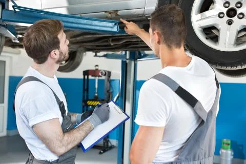 Auto workshop mechanics inspecting damage to car Stock Photos