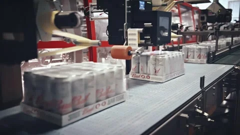 Automated beer packaging machine labeling cans on a conveyor belt Stock Footage 337411254