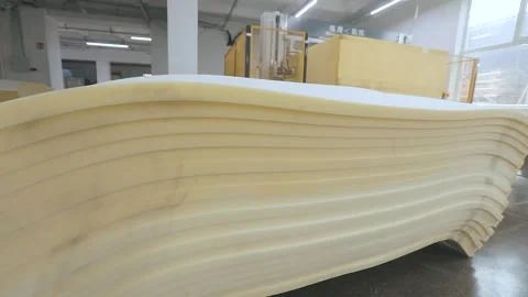 Automated CNC foam cutting machine processing a large block of polyurethane foam Video stock 347575879