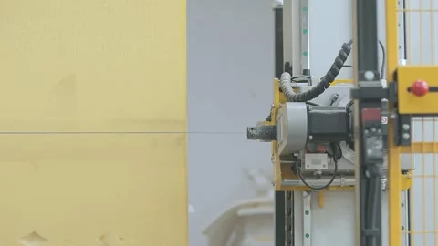 Automated CNC foam cutting machine processing a large block of polyurethane foam Stock Footage 347575899
