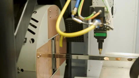 Automated CNC laser cutting machine processing a square metal pipe with bright Stock Footage 345892726