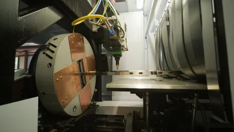 Automated CNC laser cutting machine processing a square metal pipe with bright Stock Footage 345892905