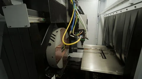 Automated CNC laser cutting machine processing a square metal pipe with bright Stock Footage 345892984