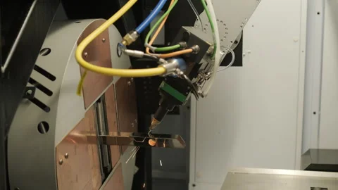 Automated CNC laser cutting machine processing a square metal pipe with bright Stock Footage 345894482