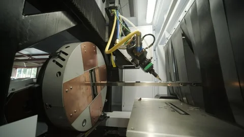 Automated CNC laser cutting machine processing a square metal pipe with bright Stock Footage 345894483