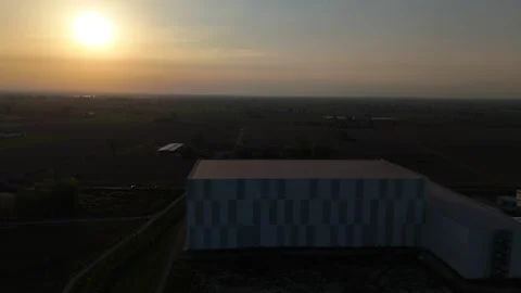 Automated cold storage warehouse in Po Valley at sunset aerial pullback Stock Footage 334404463