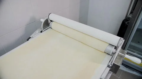Automated Dough Sheeter Machine Rolling Pastry in a Commercial Bakery Stock Footage 321285675