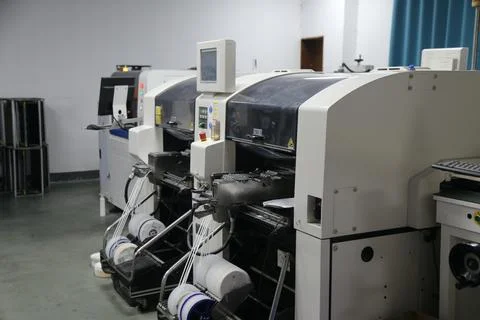 Automated electronics assembly machines lined up with component feeder reel.. Fotos de archivo