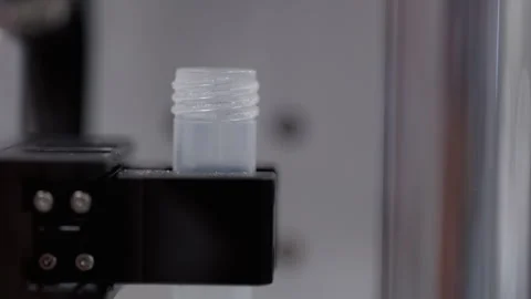 Automated equipment opens and closes test tube cap in lab chamber closeup Stock Footage 346610895