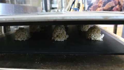 Automated food processing machine forming and depositing brown rice portions on Video stock 343028797