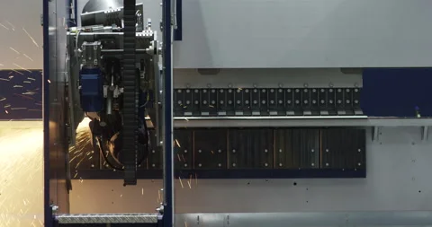 Automated industrial machine processing metal parts with sparks in factory Stockbeeldmateriaal 329498257