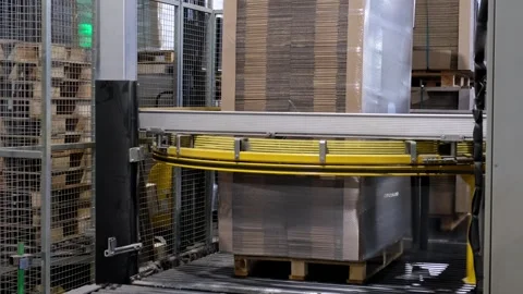 Automated industrial wrapping machine packaging a large pallet of stacked c.. Vidéo 337667906