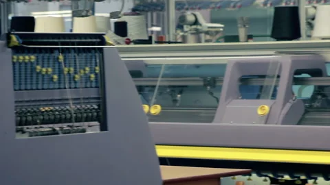 Automated knitting machines working textile plant. Camera pan white yarn spools. Stock Footage 345889837