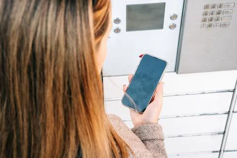 Automated locker. Parcel courier box in woman hands at post delivery automat  Photos