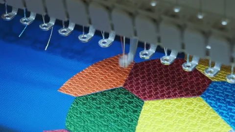 An automated machine embroiders a multi-color geometric pattern on fabric Stock Footage 225500763