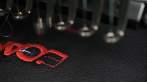 An automated machine embroidery pattern with red threads on a black cloth. Robot Stock Footage 108665257