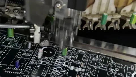 Automated machine inserting green capacitors onto circuit board 库存影片 348694276