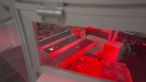 Automated machine with red laser light and circuit board panels Video stock 347981410