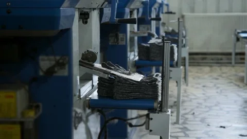 Automated machine stacks finished gloves after production. Textile factory Stock Footage 341355807